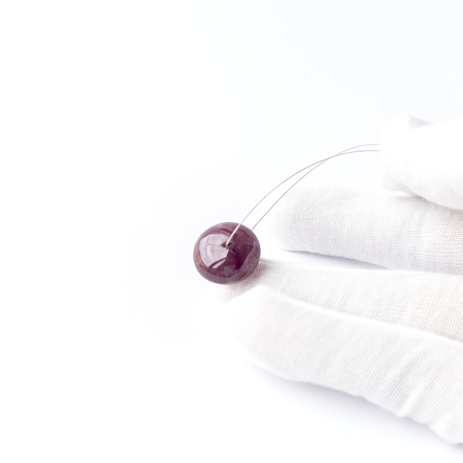 Close‑up of Ruby smooth disc cabochon showing natural inclusions, glossy shine and high‑quality craftsmanship.