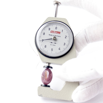 A dial gauge measures the Ruby smooth disc 17mm gemstone.