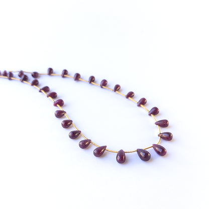 Authentic ruby gemstone beads featuring rich red colour and glossy smooth drop finish for premium jewellery.