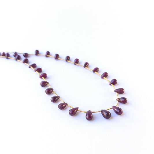 Authentic ruby gemstone beads featuring rich red colour and glossy smooth drop finish for premium jewellery.