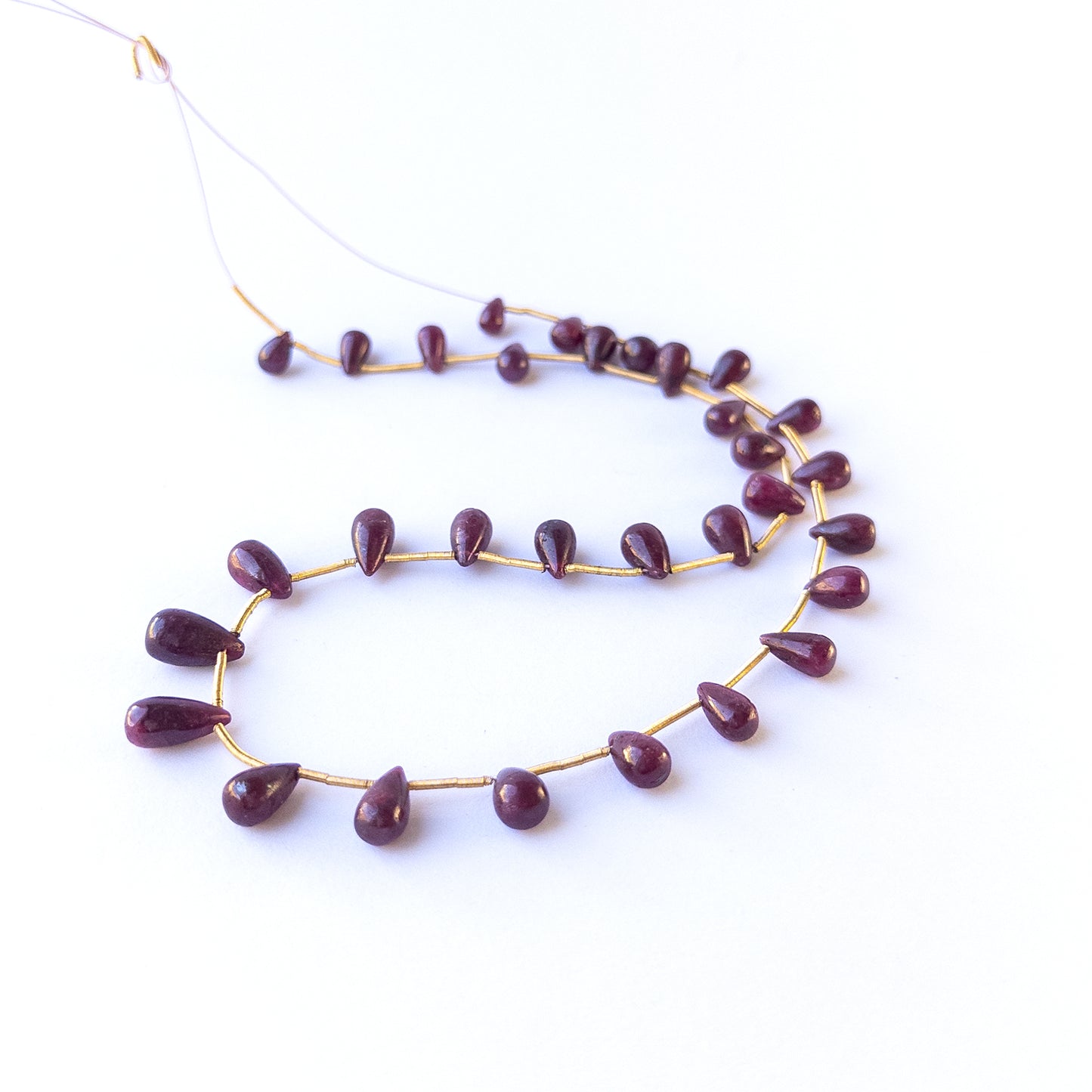 Ruby smooth drop gemstone beads in 5.5–6mm sizes, showcasing deep red tones for handmade jewellery designs.