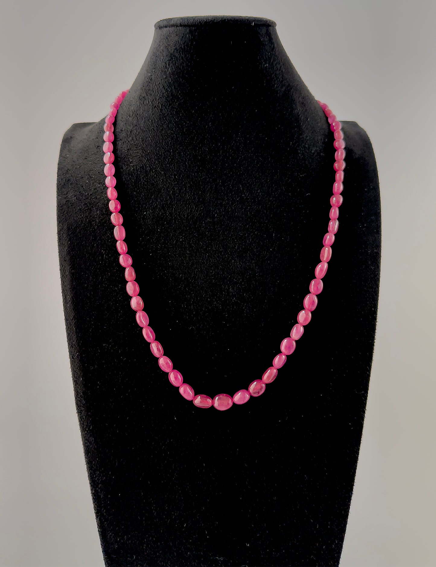 Handcrafted Ruby necklace with smooth oval beads, offering vibrant colour saturation and an elegant elongated bead profile.
