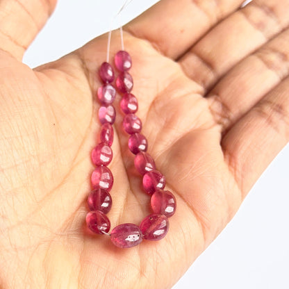 Smooth oval ruby stone beads arranged on a 36cm strand, perfect for handmade jewellery components.