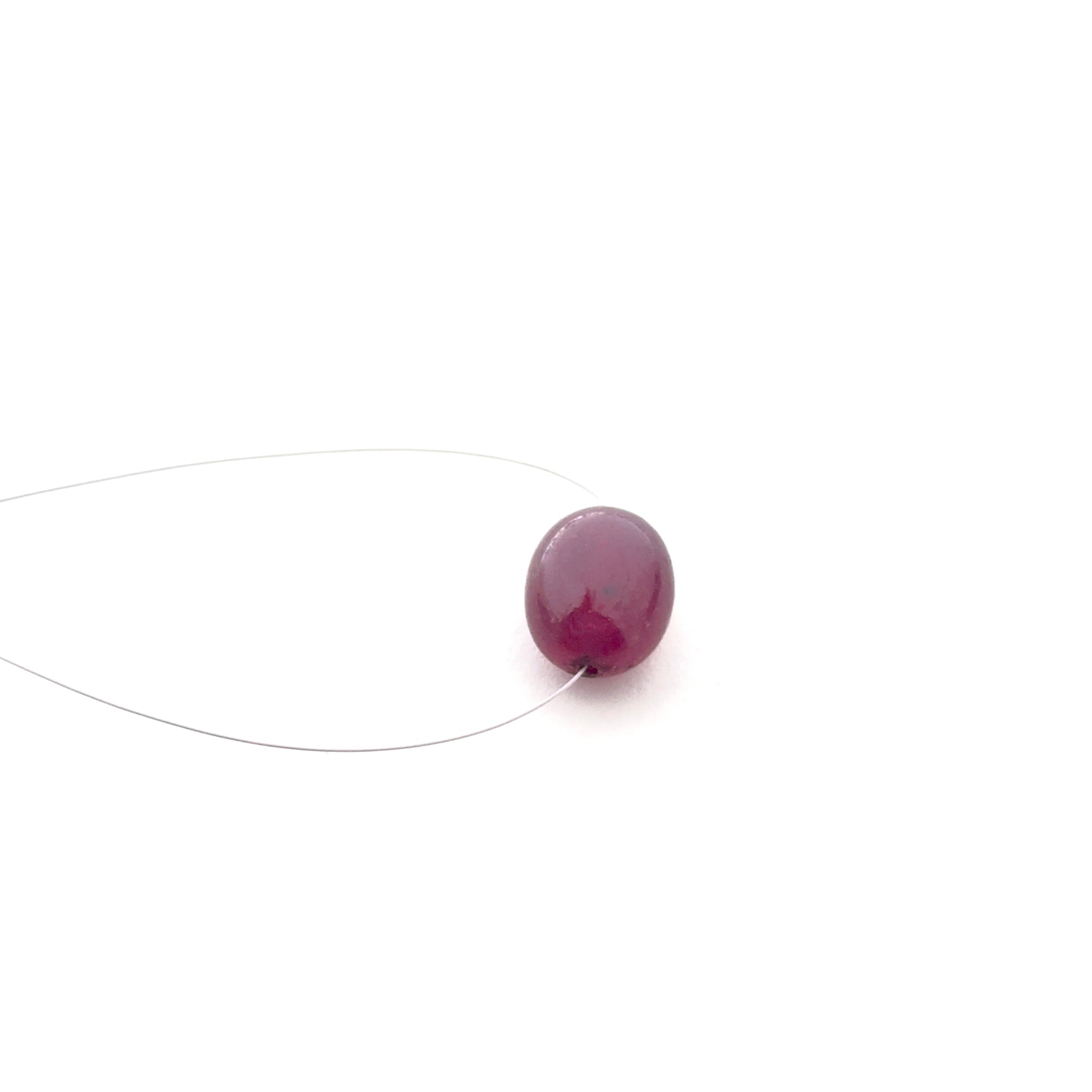 Close‑up of ruby smooth oval stone bead highlighting its deep red tone and glossy surface for DIY jewellery making.