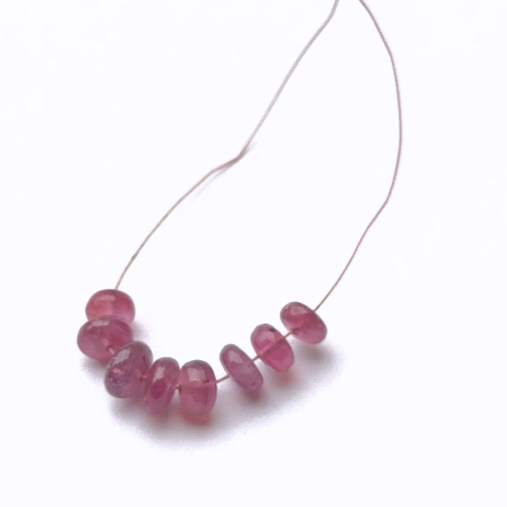 Ruby gemstone beads neatly aligned to showcase cut and quality.