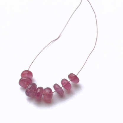 Ruby gemstone beads neatly aligned to showcase cut and quality.
