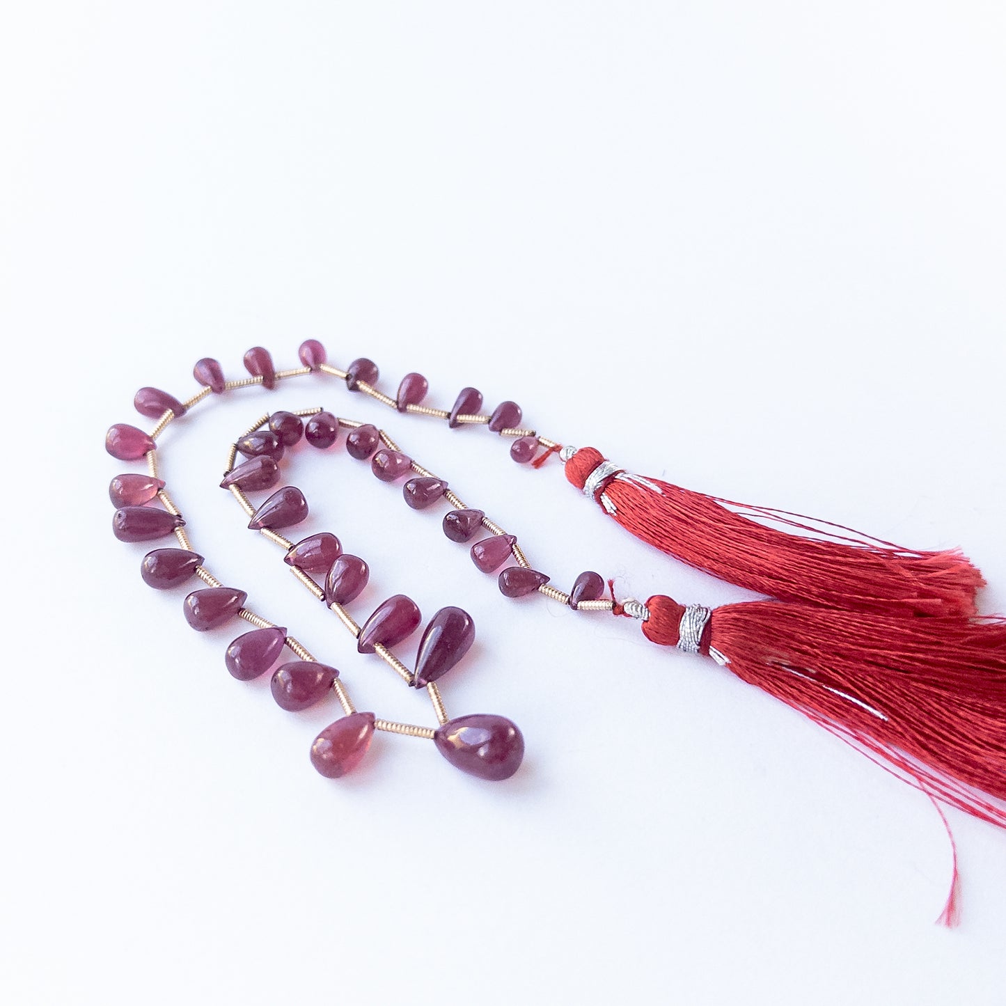 Close‑up of genuine Ruby smooth briolette beads highlighting their shine, clarity and polished finish.
