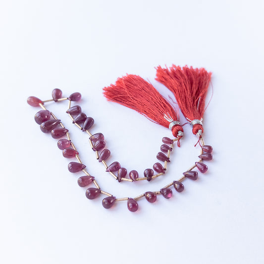 Natural Ruby smooth briolette stones displaying rich red tones and varied teardrop shapes.