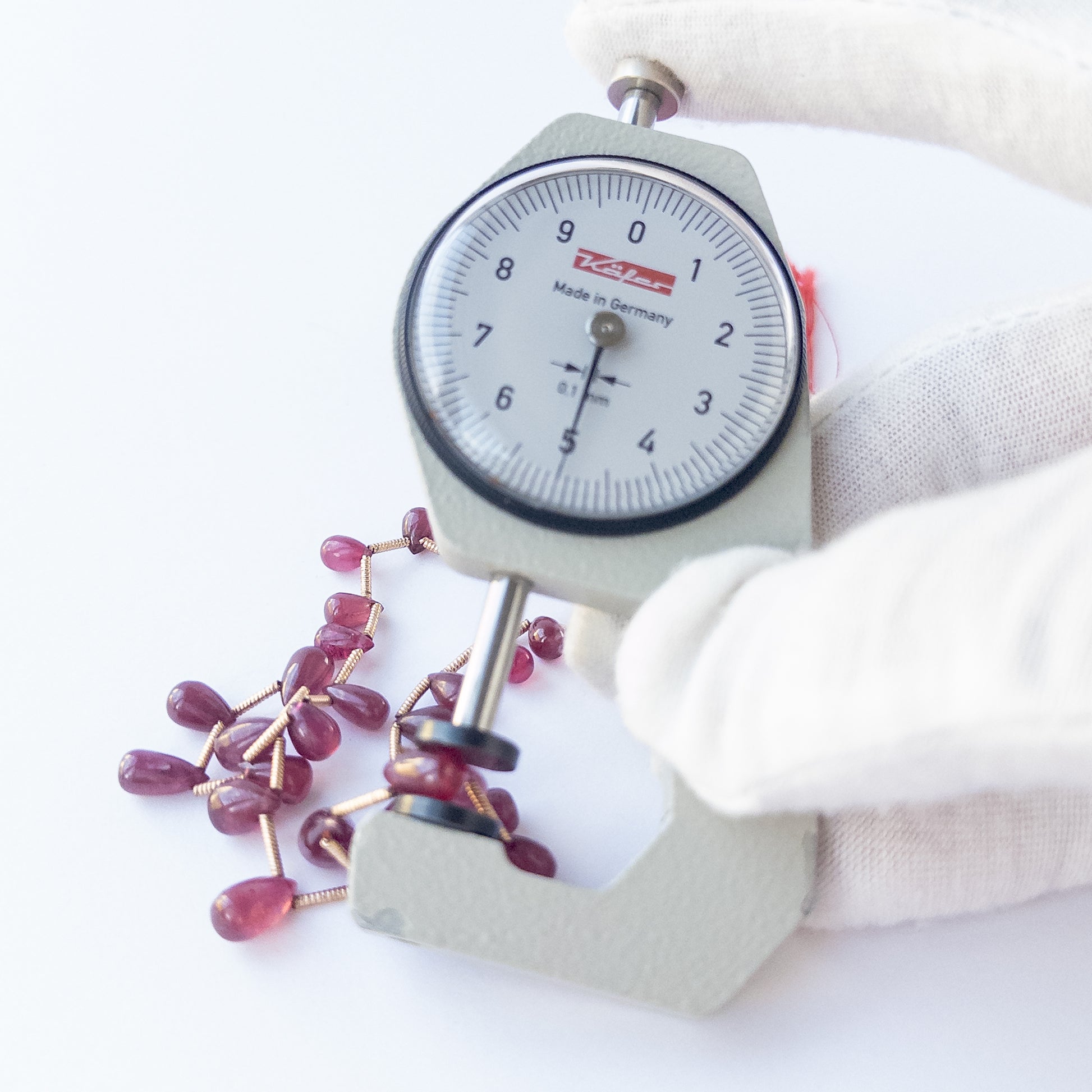 A dial gauge measures the Ruby smooth briolette 3.1–7mm gemstone. 