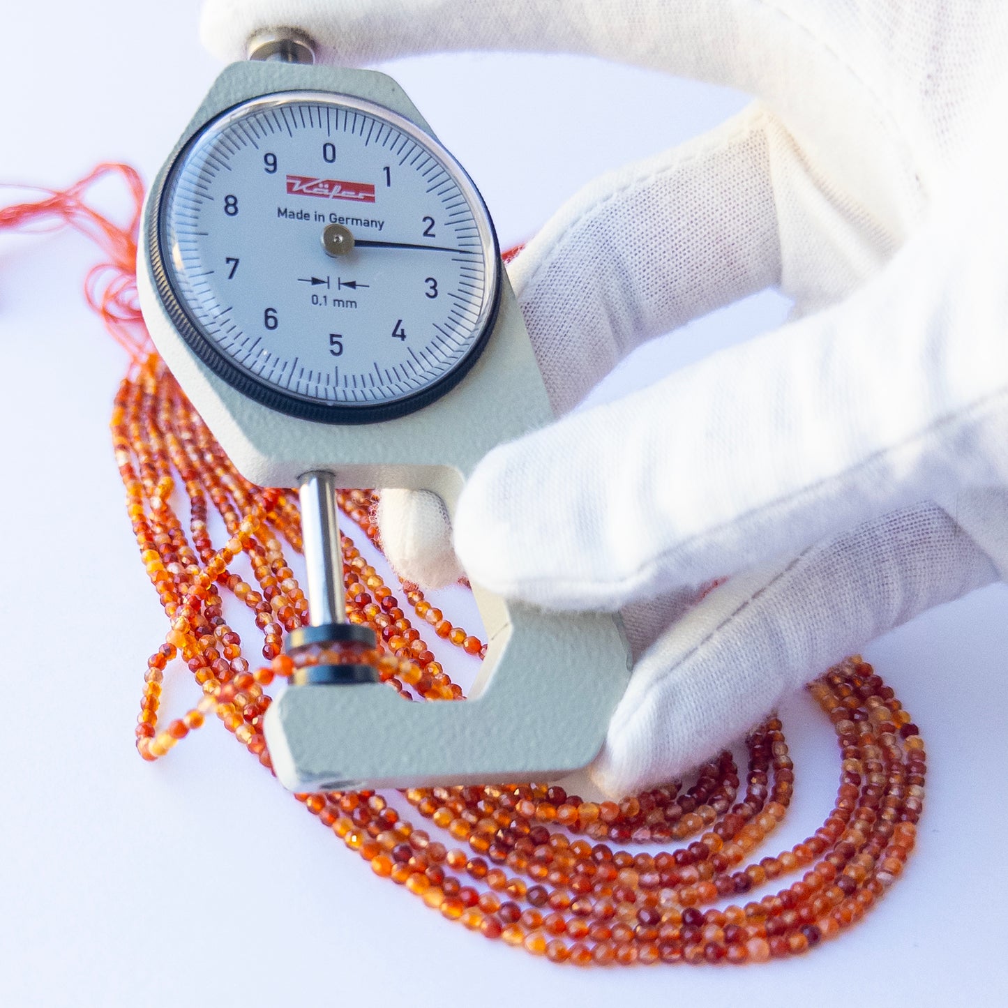 A dial gauge measures the Rutile faceted rondelle 2.4mm gemstone.