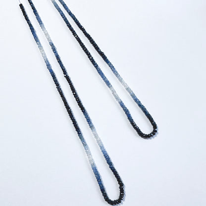 Gradient blue sapphire rondelle beads with faceted surfaces reflect light beautifully across the full strand.