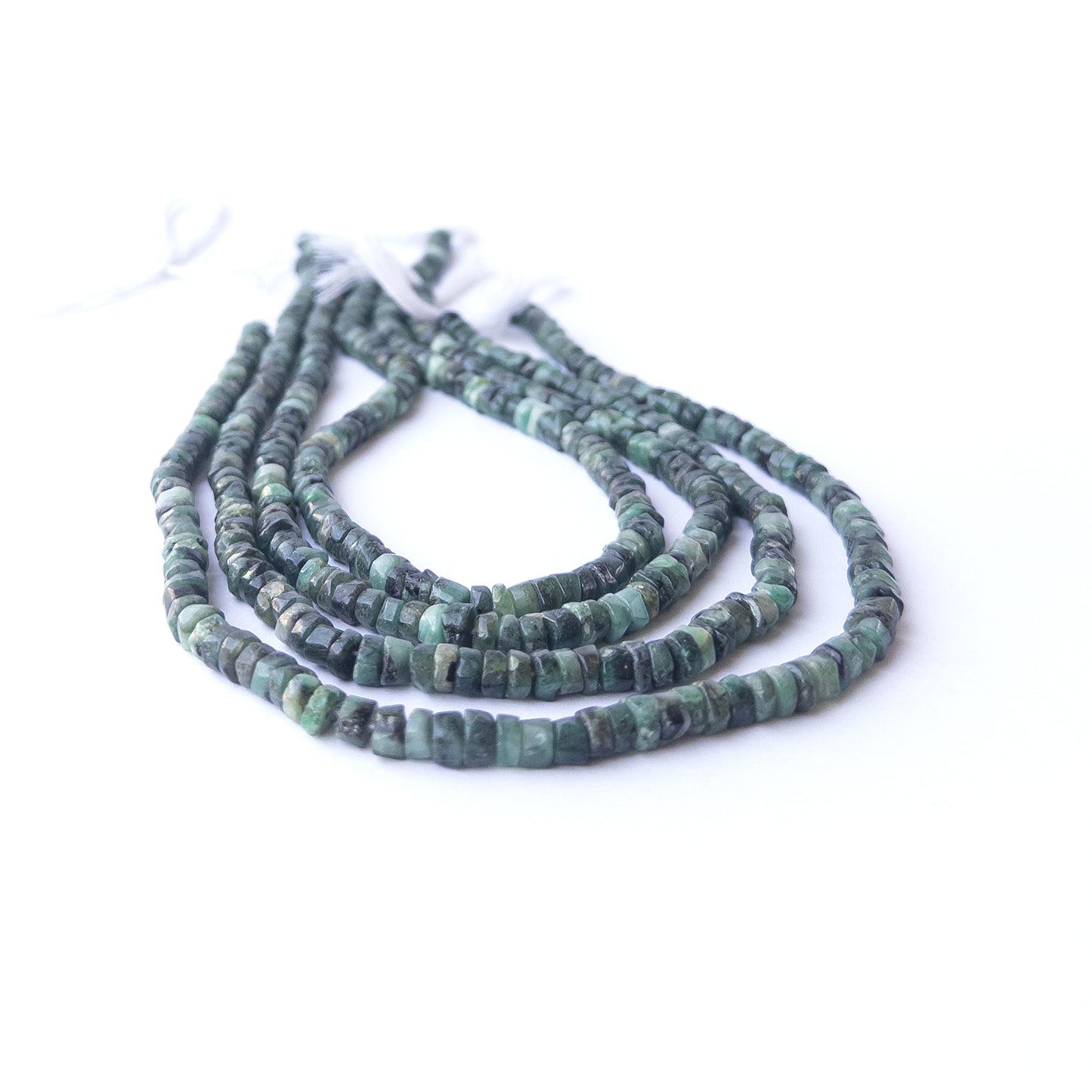 Close‑up of genuine Shaded Emerald smooth wheel beads showing polished shine and natural green tones.