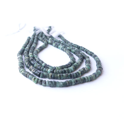 Close‑up of genuine Shaded Emerald smooth wheel beads showing polished shine and natural green tones.