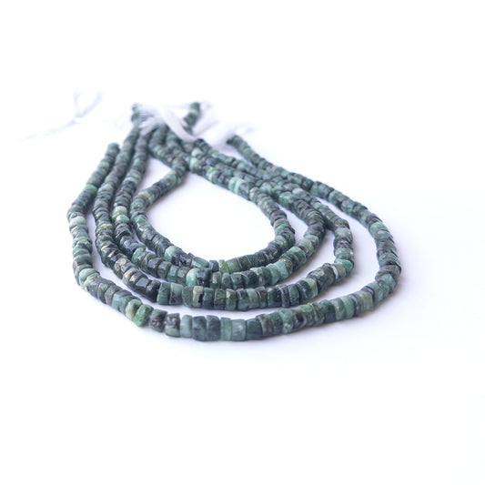 Close‑up of genuine Shaded Emerald smooth wheel beads showing polished shine and natural green tones.