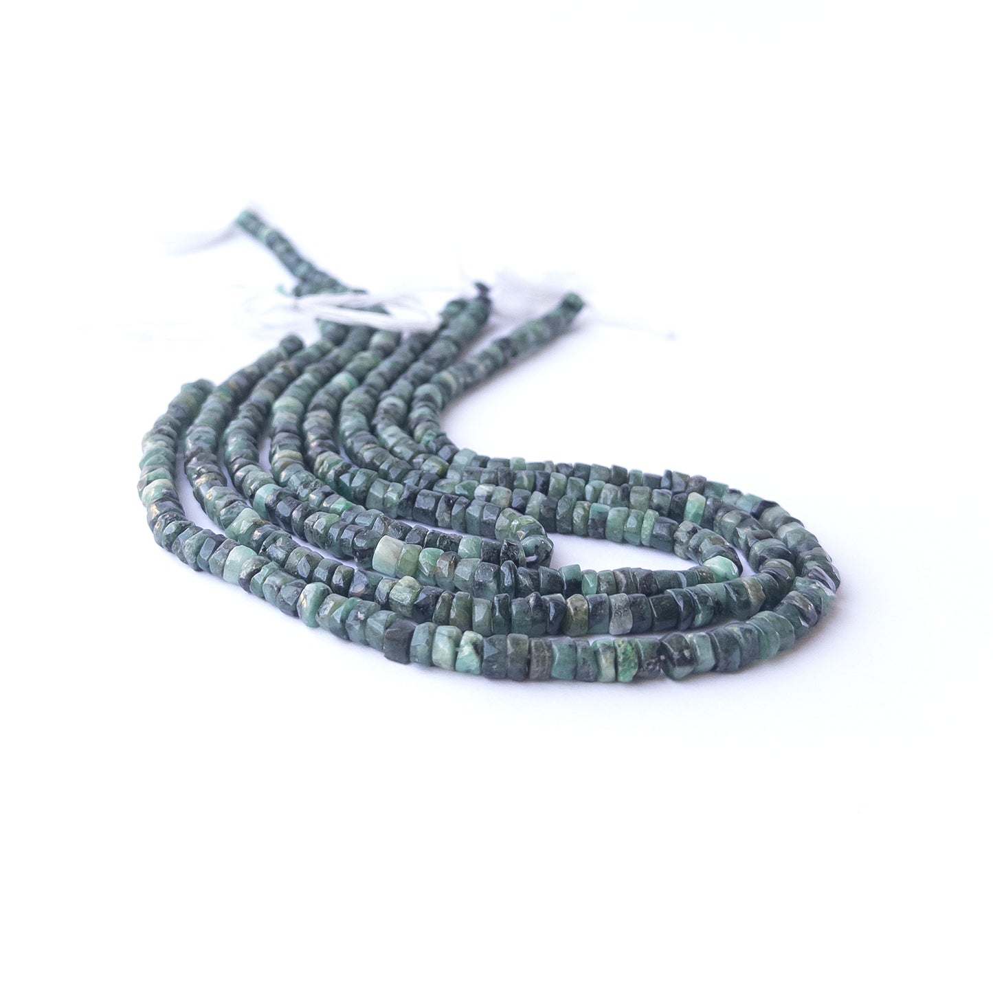 Handmade jewellery components featuring smooth Shaded Emerald wheel beads in a neatly arranged strand.