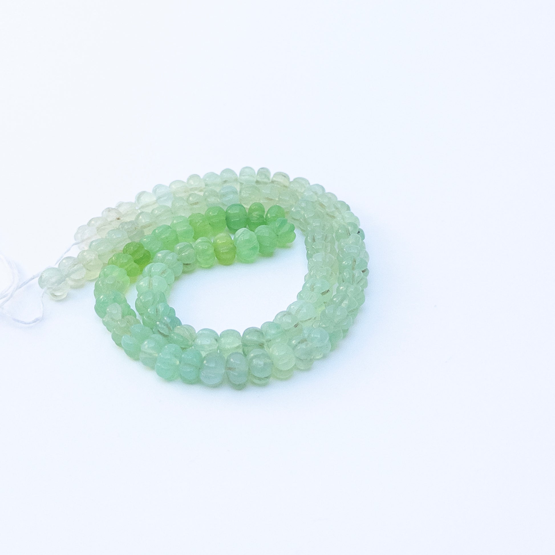 Handmade jewellery components featuring Shaded Green Chalcedony beads with soft shimmer and refined carved texture.