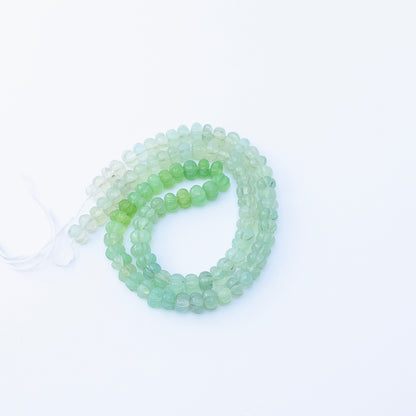 Close‑up of Shaded Green Chalcedony pumpkin cut beads highlighting their glossy finish and gradient green hues.