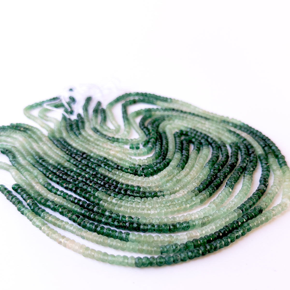 Close‑up of Shaded Green Quartz faceted rondelle beads revealing clarity, shine and fine craftsmanship.
