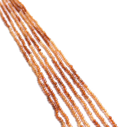 Close‑up of shaded hessonite faceted rondelles highlighting their polished cut and natural gemstone shine.