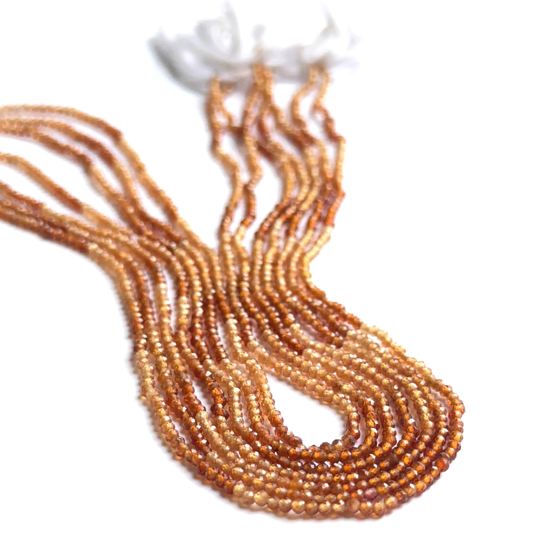 Shaded hessonite faceted rondelles photographed to show brilliance, warm hues and gemstone quality.
