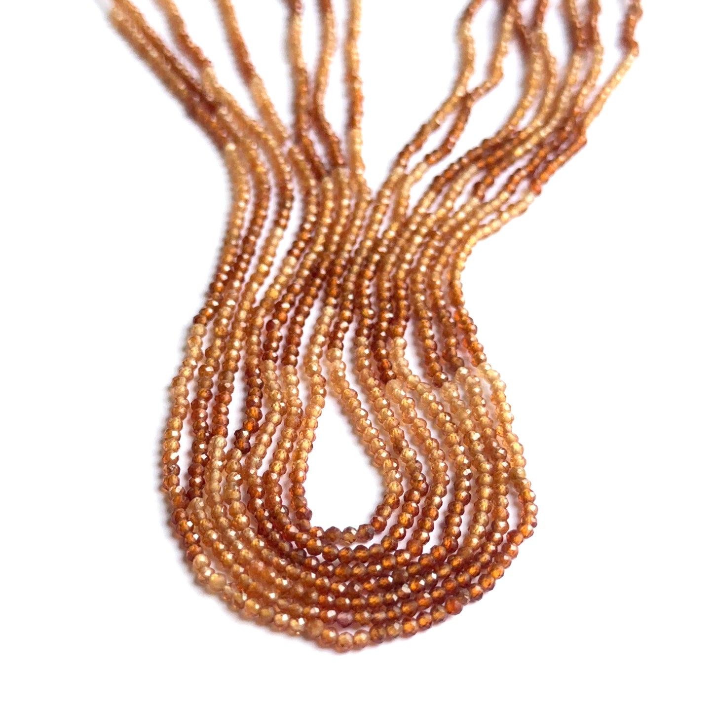 Shaded hessonite gemstone rondelles arranged neatly to showcase clarity, colour and precision faceting.