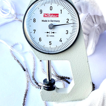 A dial gauge measures the smoky quartz rondelle 2.2mm gemstone.