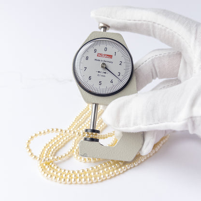 A dial gauge measures the Shell Pearl smooth round 3.4mm gemstone.