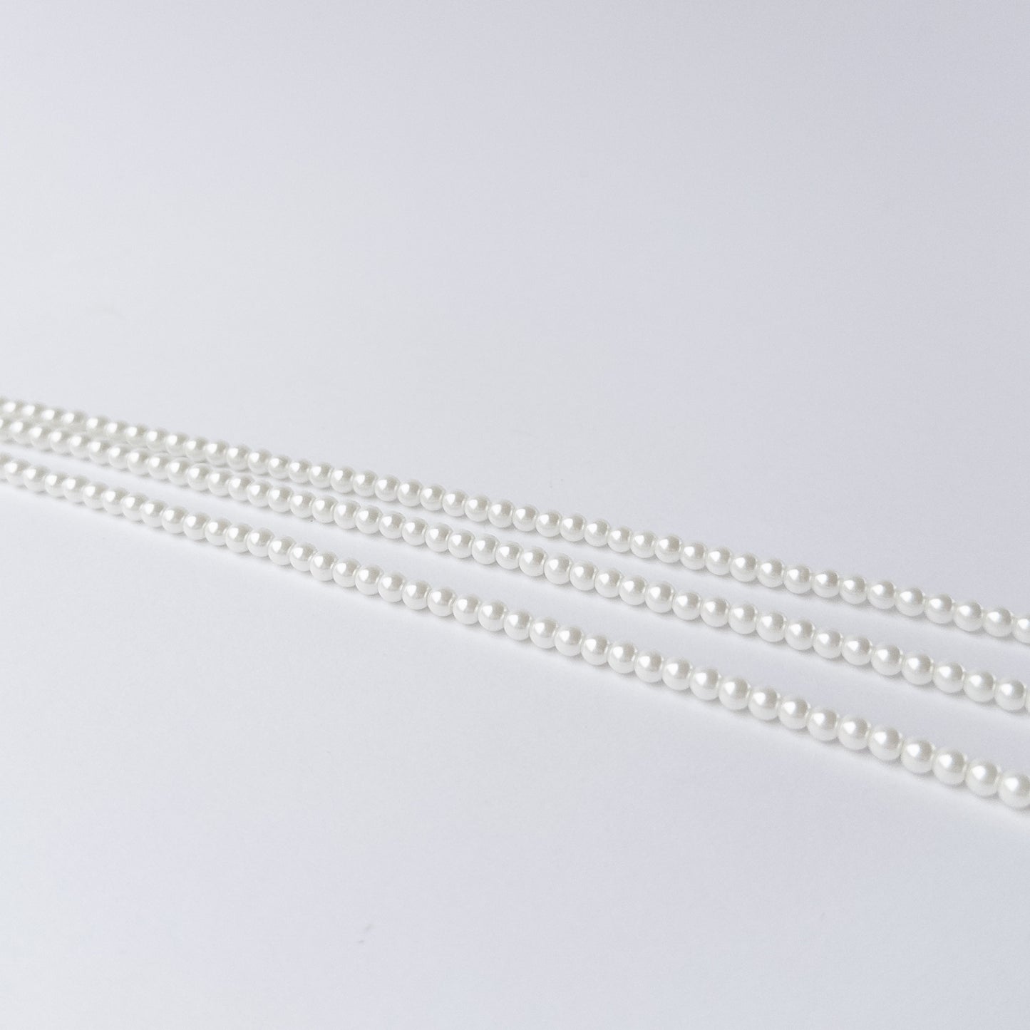 Shell Pearl gemstone beads arranged in a long strand for DIY jewellery and creative designs.