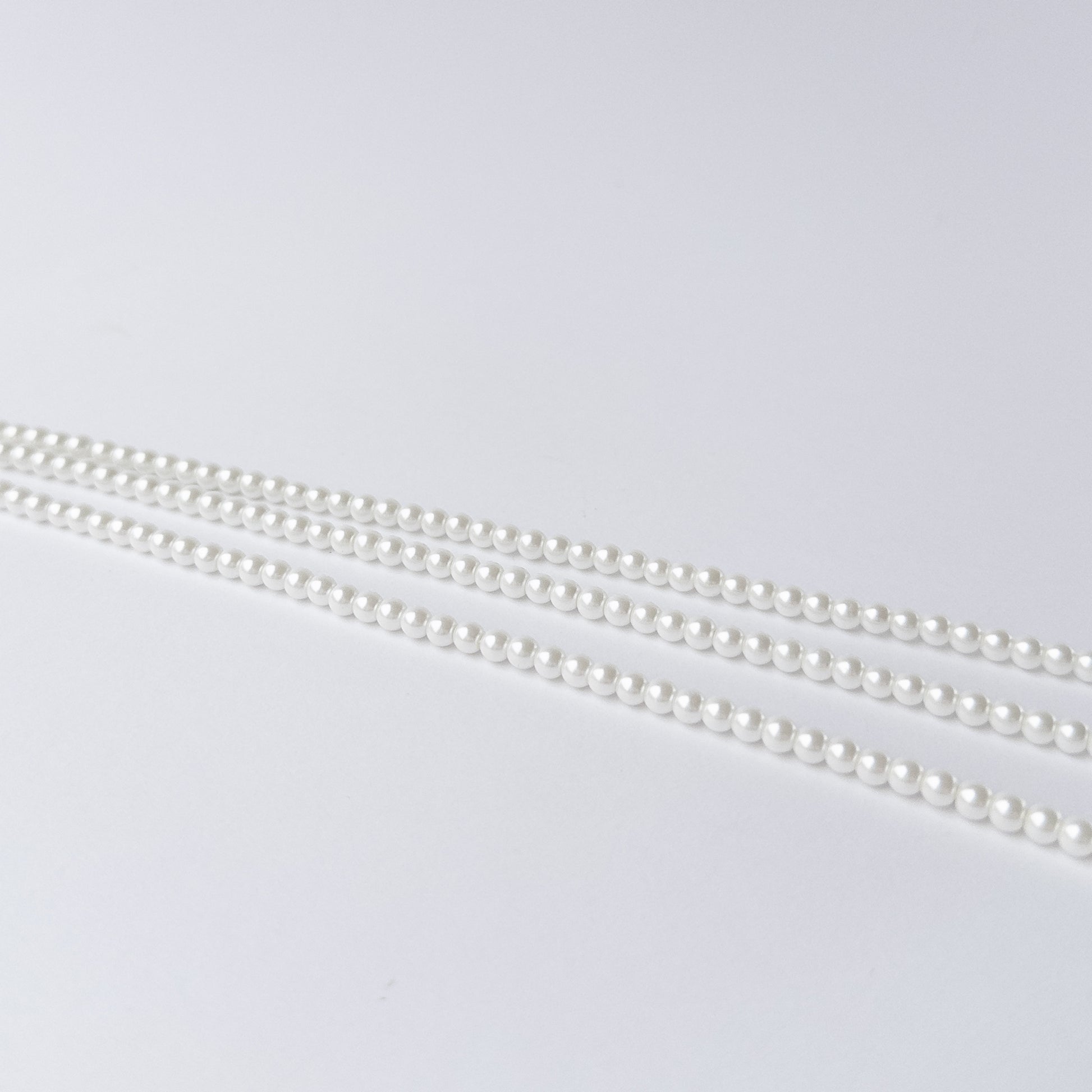 Shell Pearl gemstone beads arranged in a long strand for DIY jewellery and creative designs.