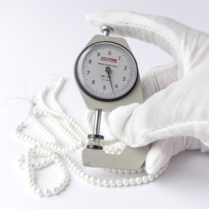 A dial gauge measures the Shell Pearl smooth round 4.4mm gemstone.