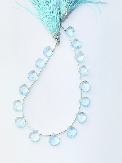 Close‑up of Sky Blue Topaz stone beads arranged in a strand with shimmering faceted surfaces.