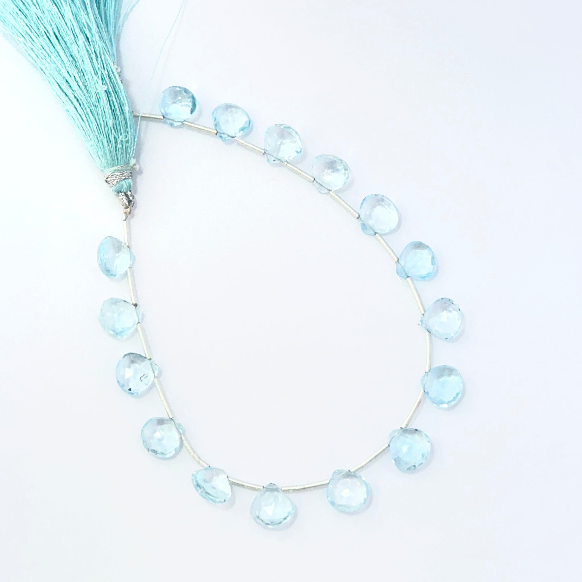 Sky Blue Topaz faceted briolette beads showing bright blue sparkle and polished gemstone cuts.