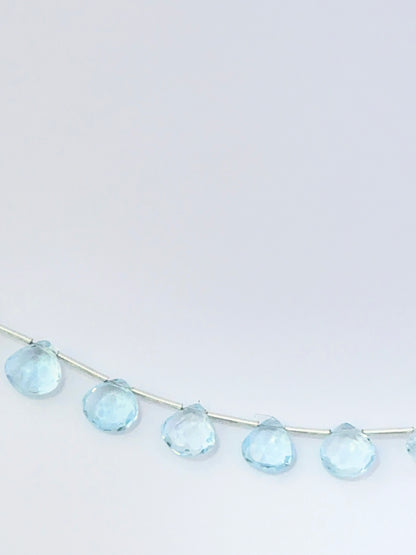 Stone beads made from Sky Blue Topaz showing polished briolette shapes and clear brilliance.