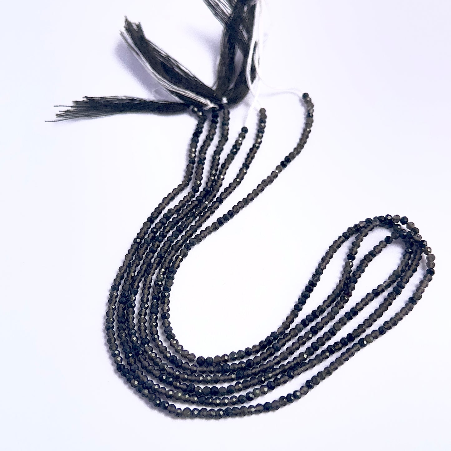 Close-up of Smoky Quartz gemstone beads showing faceted rondelle cut and sparkle.