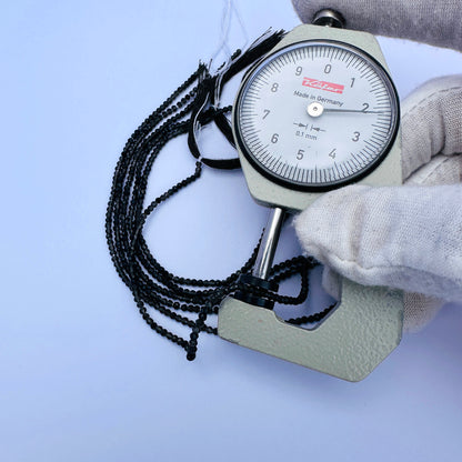 A dial gauge measures the Smoky Quartz faceted rondelle 2.2mm gemstone.