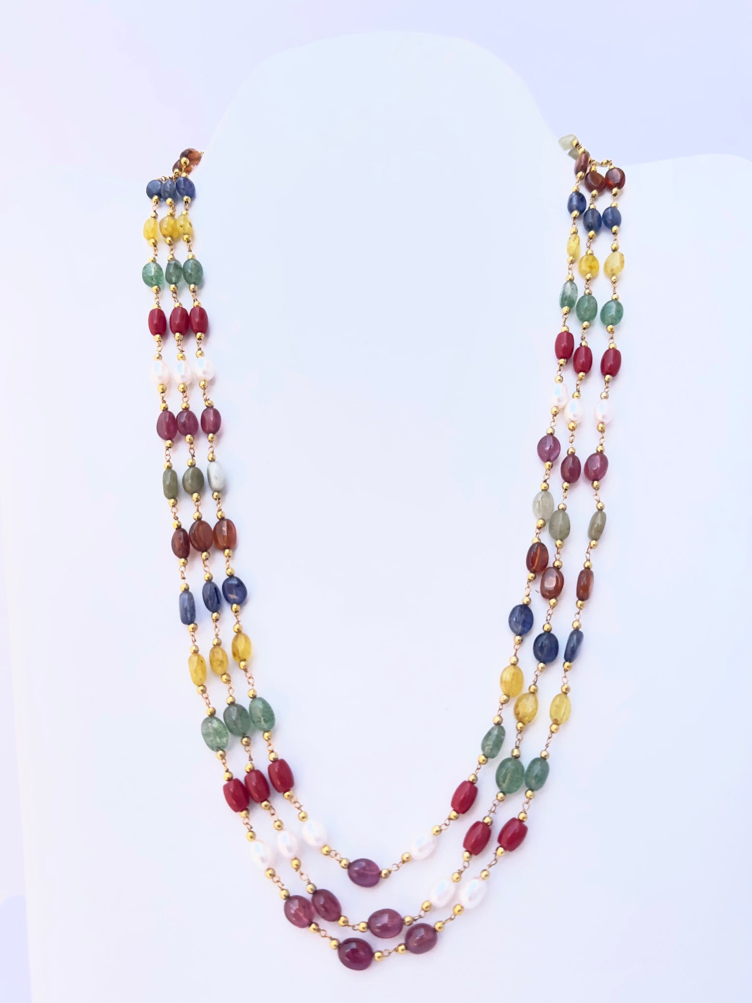 Navratan multi precious necklace with smooth oval beads, three strands, radiant gemstone colours.