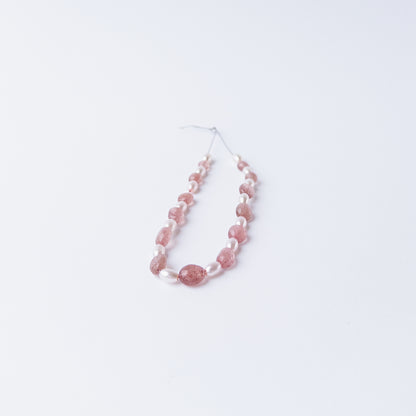 High quality Strawberry Quartz and Shell Pearl gemstone beads arranged for artisan beadwork.