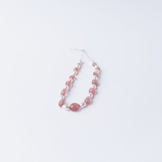 High quality Strawberry Quartz and Shell Pearl gemstone beads arranged for artisan beadwork.
