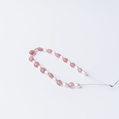 Close‑up of Strawberry Quartz and Shell Pearl beads highlighting their polished finish and shape.