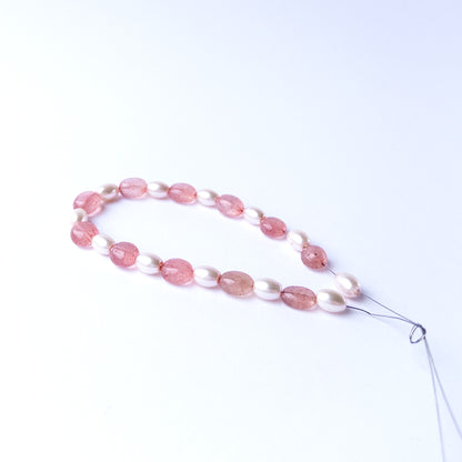 High quality Strawberry Quartz and Shell Pearl gemstone beads arranged for artisan beadwork.