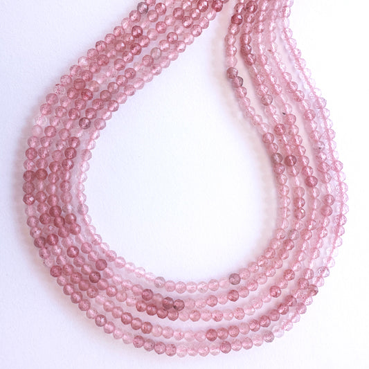 Close-up of Strawberry Quartz stone beads with faceted rondelle cut, showcasing soft pink tones for handmade jewellery components.