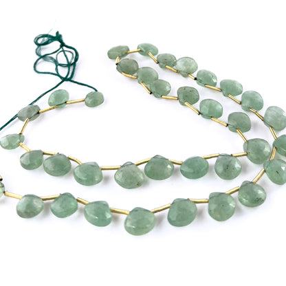 Close‑up of Green Strawberry Quartz faceted briolette beads highlighting their reflective surfaces and sparkling green-tone inclusions.