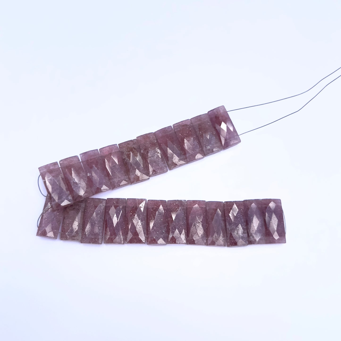 Handmade jewellery components featuring Strawberry Quartz faceted rectangle beads in delicate hues.