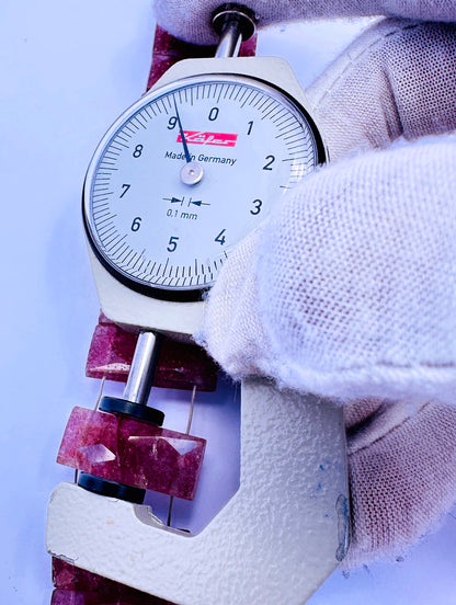 A dial gauge measures the Strawberry Quartz faceted rectangle 21×9.2–9.5mm gemstone.