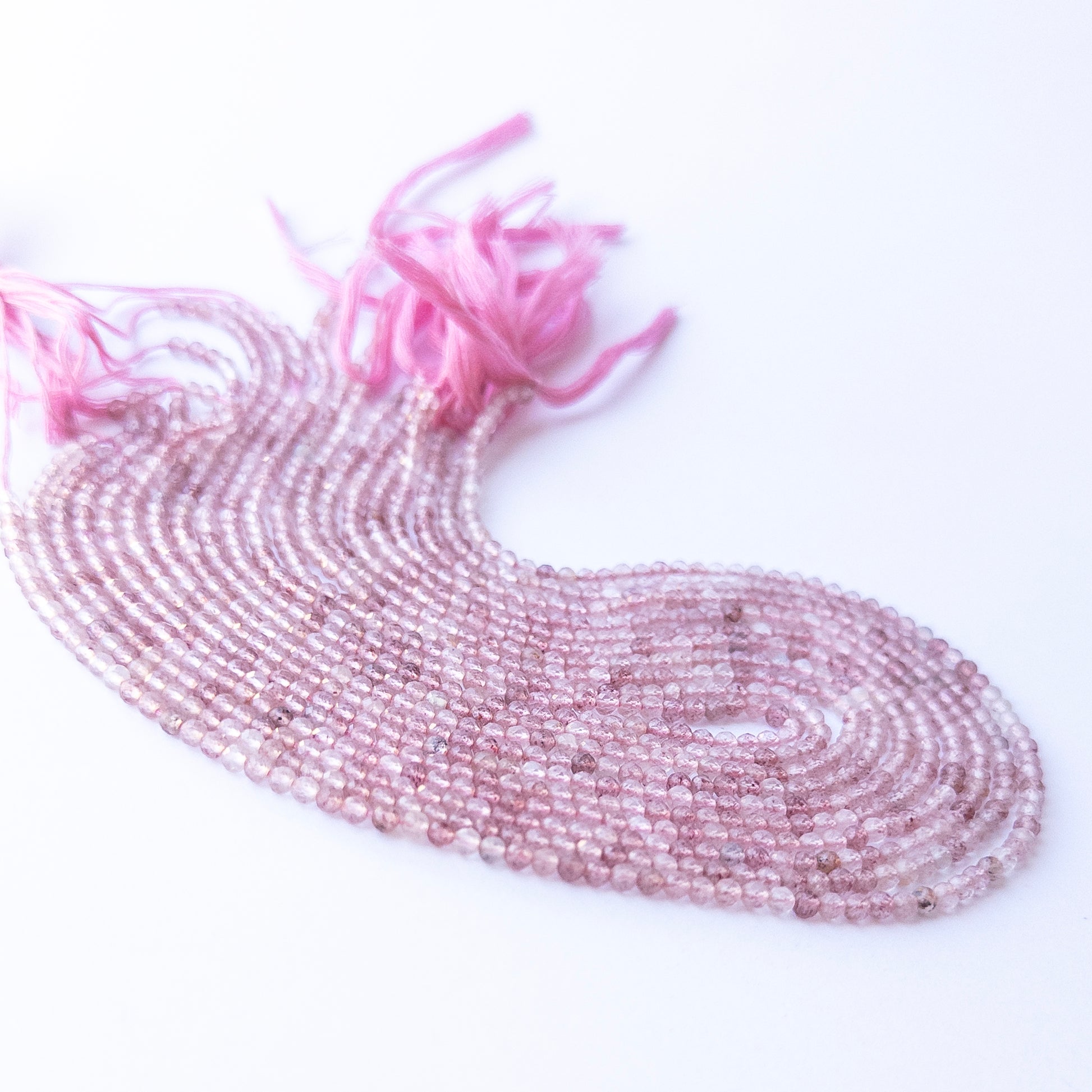 Genuine Strawberry Quartz gemstone beads in faceted rondelle shape, displaying polish, shimmer, and natural beauty for jewellery crafting.