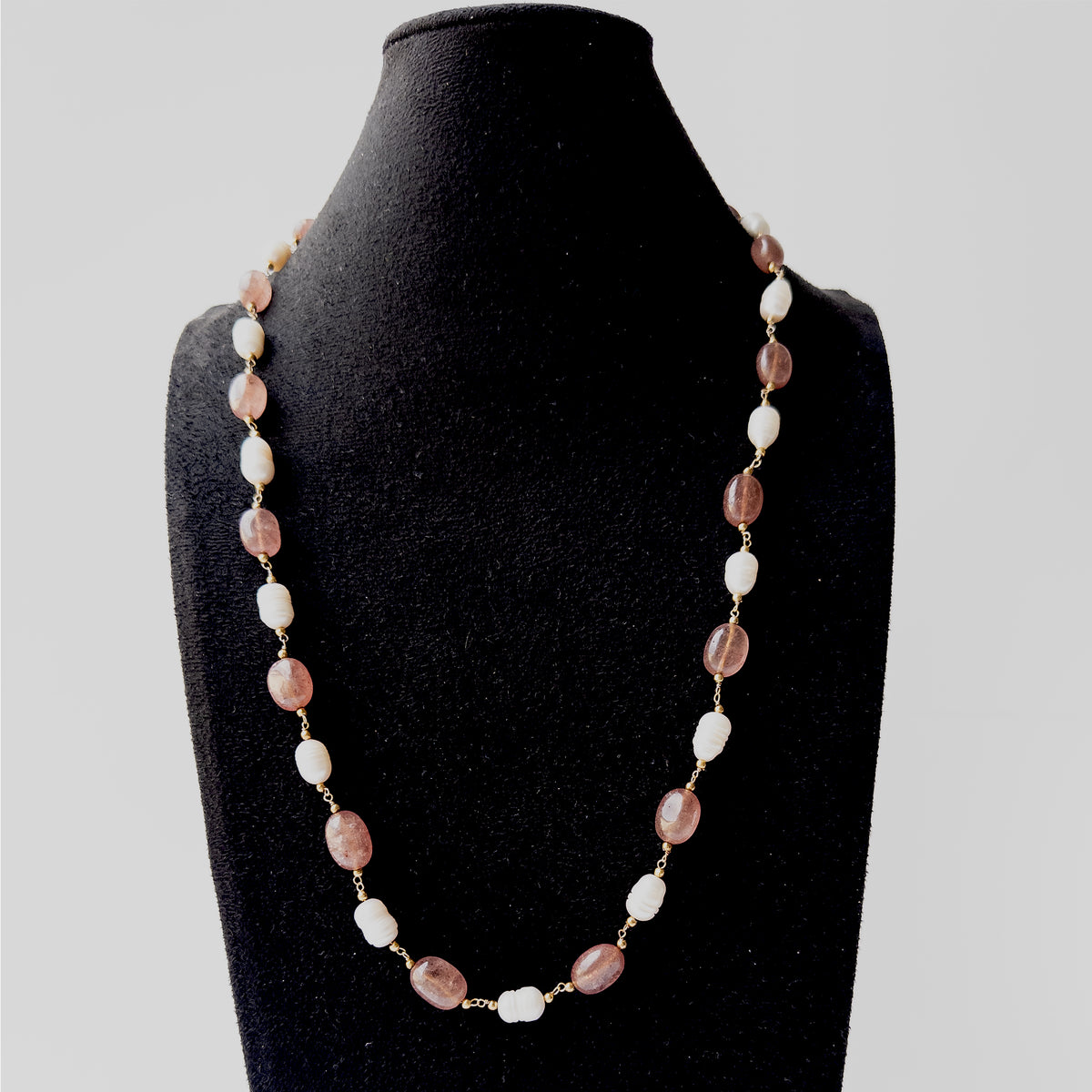 Genuine Strawberry Quartz gemstone necklace showcasing smooth oval beads and radiant Freshwater Pearl highlights.