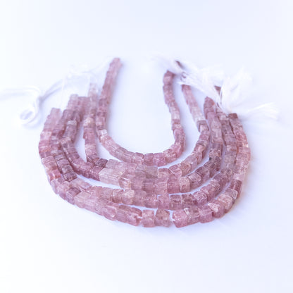 Authentic strawberry quartz gemstone beads showcasing soft pink tones and uniform cube cuts.