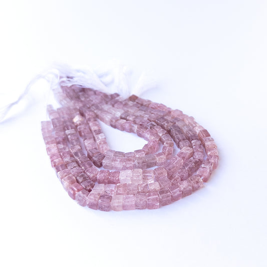 Handmade jewellery components featuring natural strawberry quartz smooth cube beads in a neatly aligned strand.
