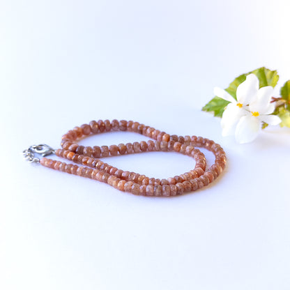 Close up of Sunstone gemstone beads showing radiant shimmer and faceted rondelle sparkle for crafting.