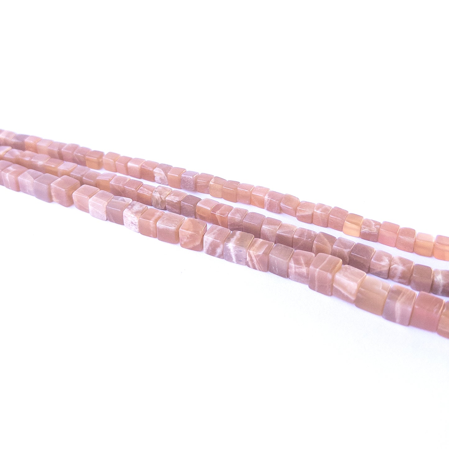 Handmade jewellery components featuring natural sunstone smooth cube beads in a neatly aligned strand.